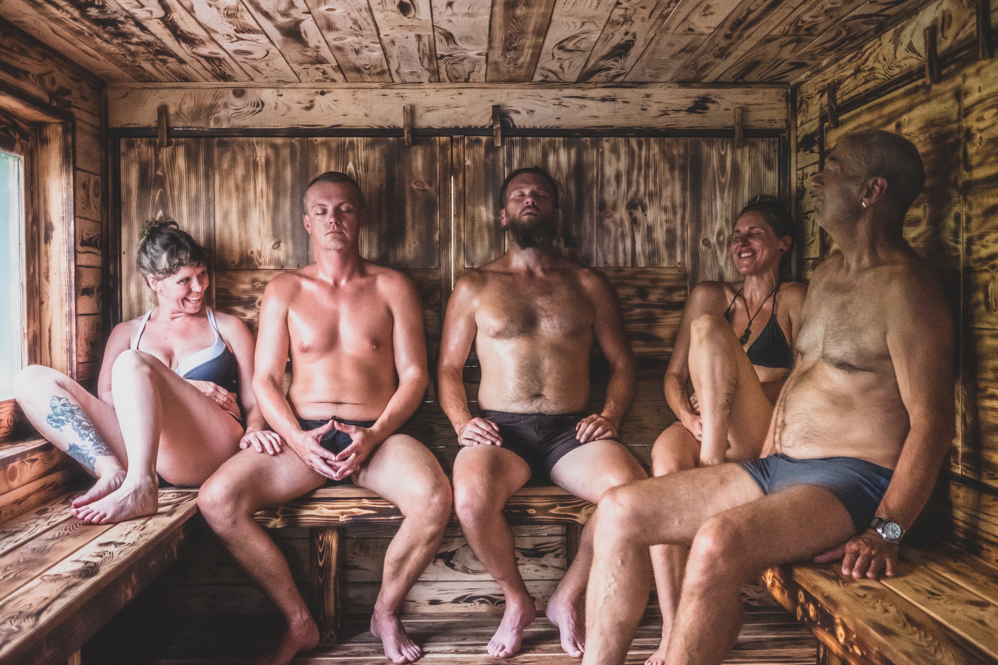Group of people sitting in a wooden sauna